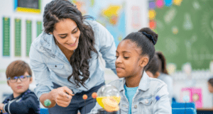 smiling woman helping young child with school work