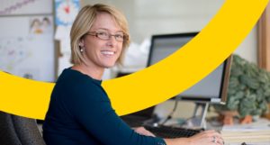 smiling teacher using a computer