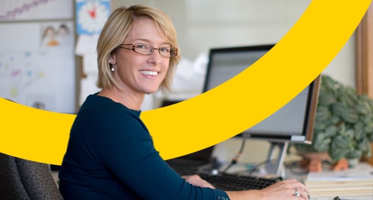 smiling teacher using a computer