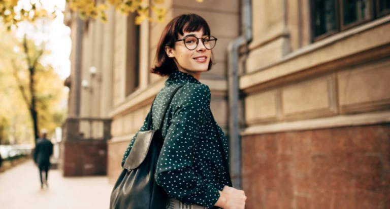 woman smiling and walking with backpack