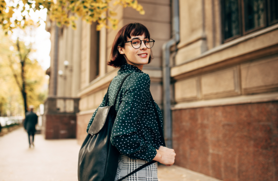 woman smiling and walking with backpack