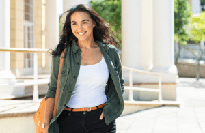 teacher in a green coat standing outside and smiling