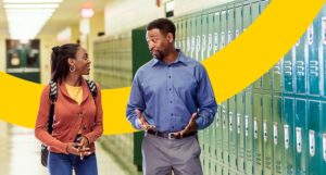 2 teachers conversing in hallway