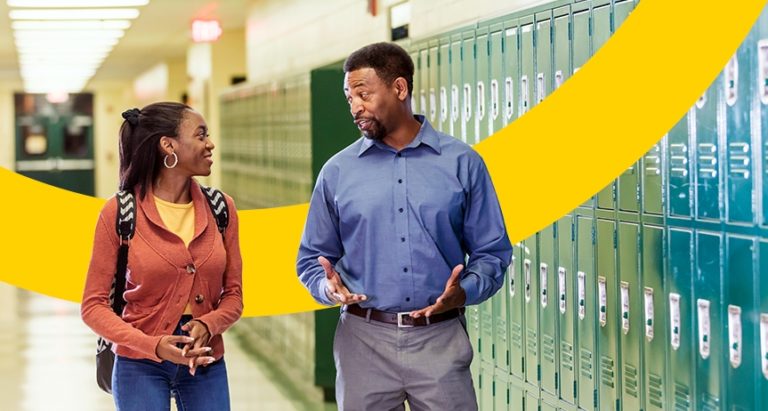 2 teachers conversing in hallway