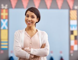 Portrait of a young female substitute teacher standing in a classroom