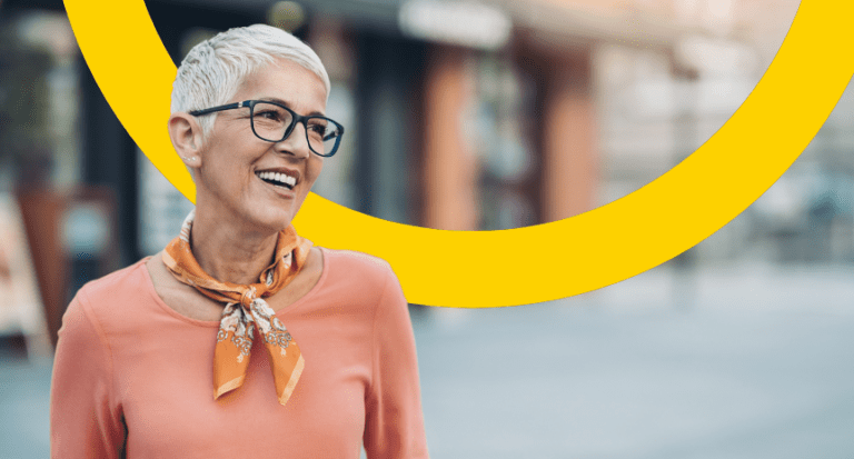 white haired woman smiling in the street