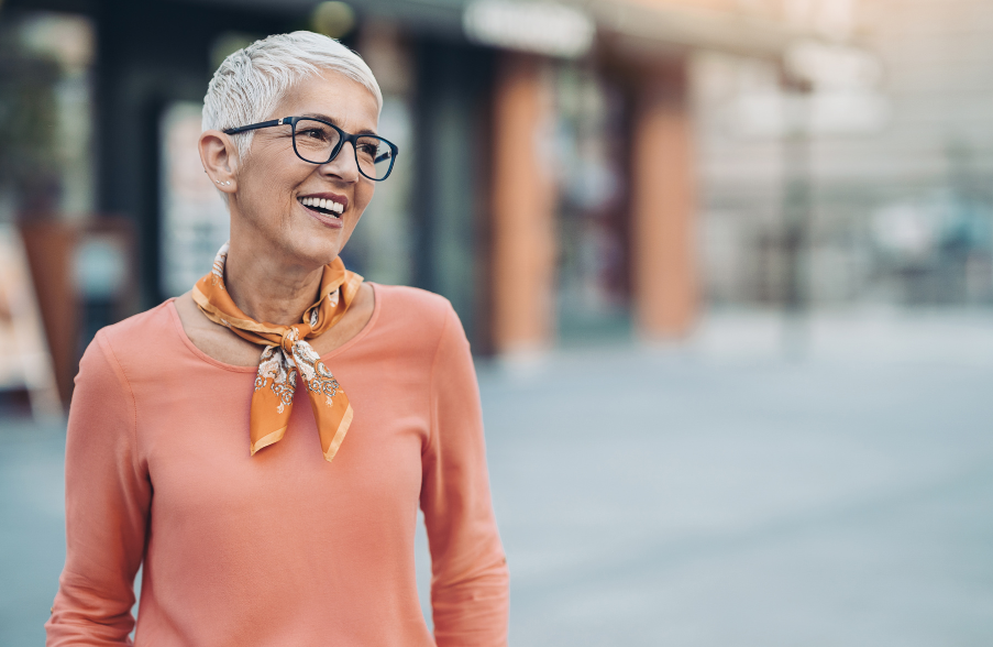 white haired woman smiling in the street