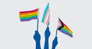 illustration of hands holding various pride month flags