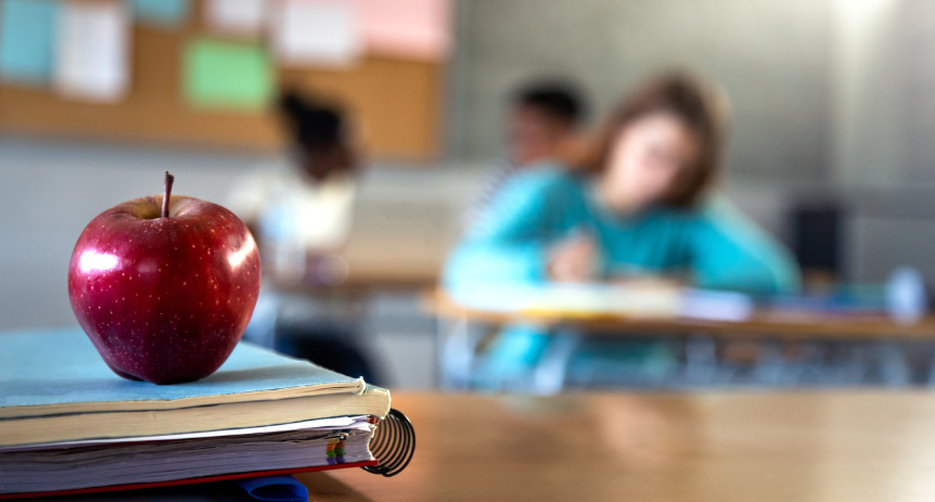 apple sitting on teachers desk
